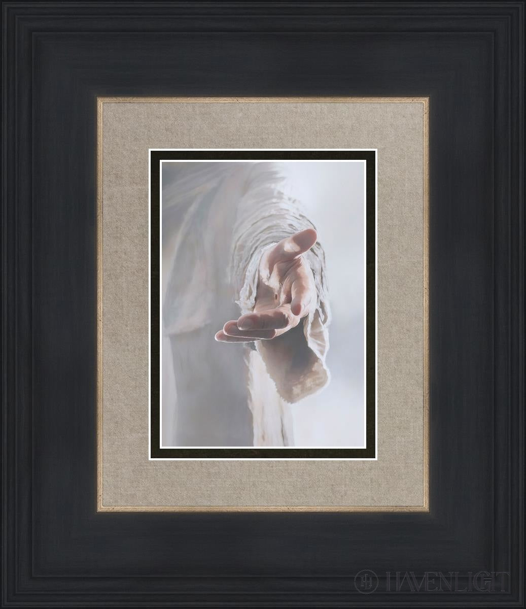 A woman prays while holding a painting depicting Jesus Christ